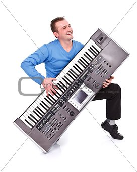 Happy man playing on synthesizer