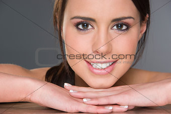 Excited Young Brunette Female Resting Head on Hands Headshot