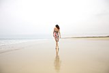 stylish woman walking on seashore