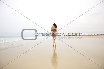 stylish woman walking on seashore