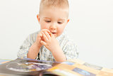 curious baby boy studying with the book