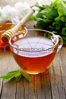 cup of tea with mint and honey on a wooden table