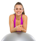 Portrait of happy fitness young woman with fitness ball