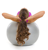 Happy fitness young woman doing abdominal crunch on fitness ball
