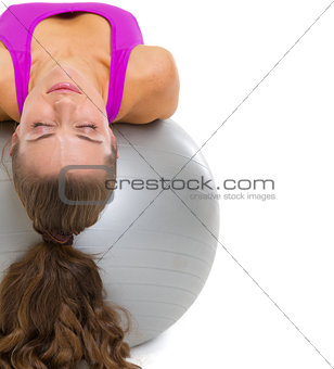 Fitness young woman laying on fitness ball