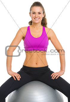 Smiling fitness young woman sitting fitness ball