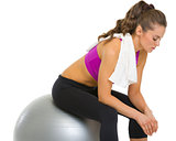 Tired fitness young woman sitting on fitness ball