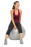 Smiling fitness young woman sitting on fitness ball