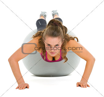 Fitness young woman doing push ups on fitness ball