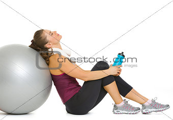Tired fitness young woman relaxing after workout on fitness ball