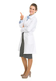 Full length portrait of woman in white robe pointing on copy spa