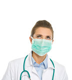Medical doctor woman in mask looking up on copy space