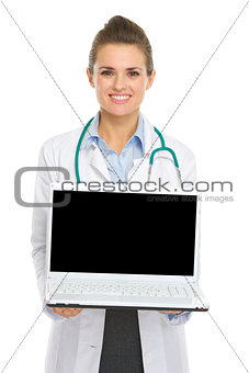 Smiling medical doctor woman showing laptop