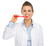 Smiling dental doctor woman showing how to clean teeth
