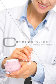 Closeup on cosmetologist woman applying creme