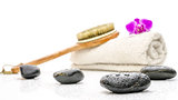 Spa setting with massage stones, brush and a towel