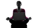 woman sitting in lotus posture computing laptop computer silhoue