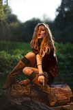Beautiful Young Woman sitting on log posing