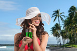 girl in bikini smiles and drinking on palm beach