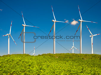 modern white wind turbine with blue sky 