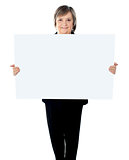 Female executive standing with a blank billboard