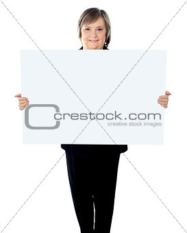 Female executive standing with a blank billboard