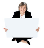 Corporate lady sitting on floor with a blank billboard