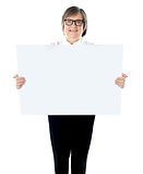 Senior businesswoman posing with blank placard