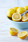 Fresh lemons in a bowl; whole and halved