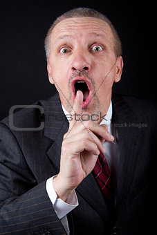 Businessman holding index finger at his mouth