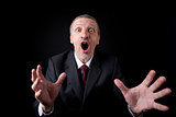 Mature businessman stretching arms and shouting