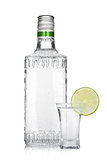 Bottle of silver tequila and shot with lime slice