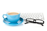 Blue coffee cup, glasses and computer keyboard