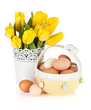 Fresh yellow tulips and eggs in bowl