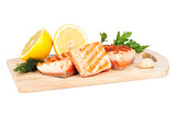 Grilled salmon with lemon and herbs on cutting board