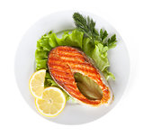 Grilled salmon with lemon slices and herbs on plate