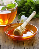 cup of tea with mint and honey on a wooden table