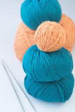 Five bright balls of yarn and two knitting needles