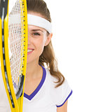 Portrait of happy female tennis player with racket