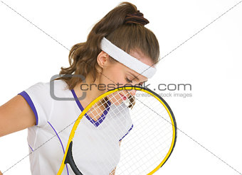 Thoughtful female tennis player holding racket