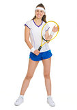 Full length portrait of smiling female tennis player with racket