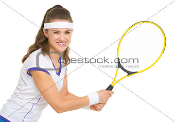 Smiling female tennis player ready to hit ball
