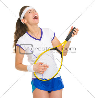 Happy female tennis player playing on racket as on guitar