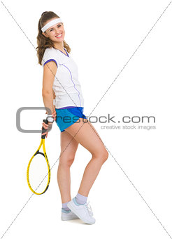 Full length portrait of smiling female tennis player with racket