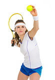 Confident female tennis player serving ball