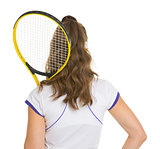 Female tennis player with racket . rear view