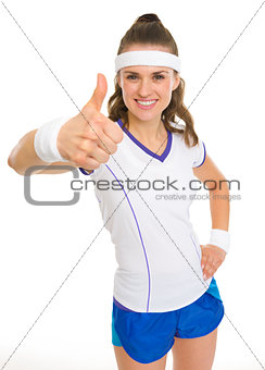 Smiling female tennis player showing thumbs up