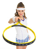 Female tennis player pointing racket in camera