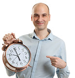 smiling guy pointing on a big alarm clock