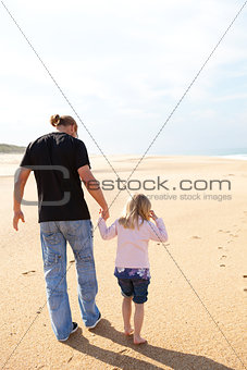 Father and daughter walking at the beach